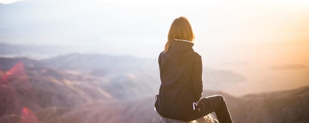 person sitting at mountaintop