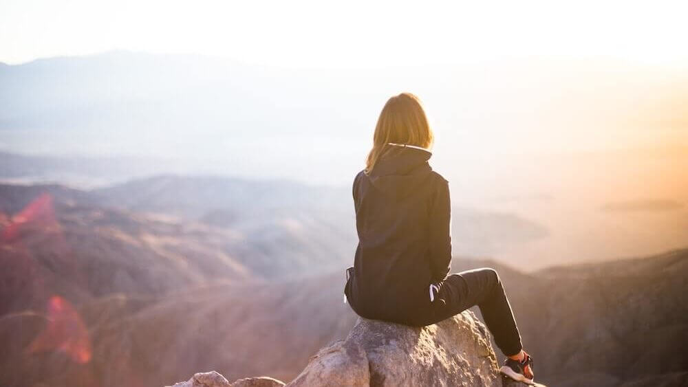 person sitting at mountaintop