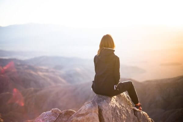 person sitting at mountaintop